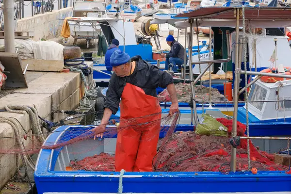 意大利 地中海 埃加迪群岛 法维纳纳岛 特拉帕尼省 2024年3月22日 港口内的渔民 渔船和渔网 Editorial 图库照片