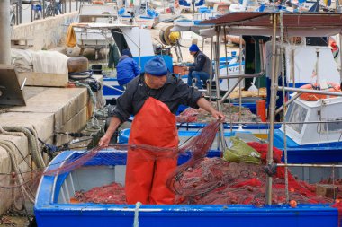 İtalya, Sicilya, Akdeniz, Egadi takımadaları, Favignana Adası (Trapani Eyaleti); 22 Mart 2024, limanda balıkçılar, balıkçılar, balıkçı tekneleri ve ağlar - EDITORIAL