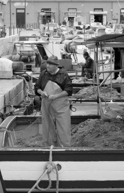 İtalya, Sicilya, Akdeniz, Egadi takımadaları, Favignana Adası (Trapani Eyaleti); 22 Mart 2024, limanda balıkçılar, balıkçılar, balıkçı tekneleri ve ağlar - EDITORIAL