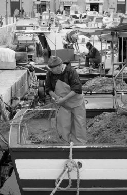 İtalya, Sicilya, Akdeniz, Egadi takımadaları, Favignana Adası (Trapani Eyaleti); 22 Mart 2024, limanda balıkçılar, balıkçılar, balıkçı tekneleri ve ağlar - EDITORIAL