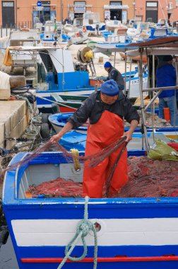 İtalya, Sicilya, Akdeniz, Egadi takımadaları, Favignana Adası (Trapani Eyaleti); 22 Mart 2024, limanda balıkçılar, balıkçılar, balıkçı tekneleri ve ağlar - EDITORIAL