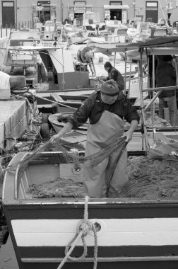 İtalya, Sicilya, Akdeniz, Egadi takımadaları, Favignana Adası (Trapani Eyaleti); 22 Mart 2024, limanda balıkçılar, balıkçılar, balıkçı tekneleri ve ağlar - EDITORIAL