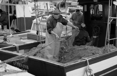 İtalya, Sicilya, Akdeniz, Egadi takımadaları, Favignana Adası (Trapani Eyaleti); 22 Mart 2024, limanda balıkçılar, balıkçılar, balıkçı tekneleri ve ağlar - EDITORIAL