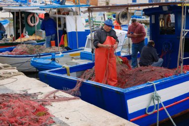İtalya, Sicilya, Akdeniz, Egadi takımadaları, Favignana Adası (Trapani Eyaleti); 22 Mart 2024, limanda balıkçılar, balıkçılar, balıkçı tekneleri ve ağlar - EDITORIAL