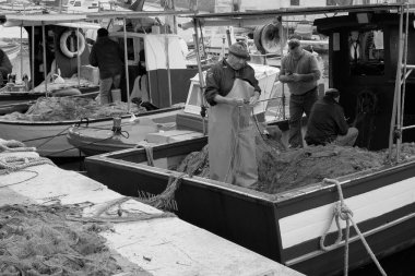 İtalya, Sicilya, Akdeniz, Egadi takımadaları, Favignana Adası (Trapani Eyaleti); 22 Mart 2024, limanda balıkçılar, balıkçılar, balıkçı tekneleri ve ağlar - EDITORIAL