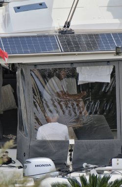 İtalya, Sicilya, Akdeniz, Marina di Ragusa (Ragusa ili); 26 Nisan 2024, limanda bir katamaran yelkenli teknesinde çift - EDITORIAL