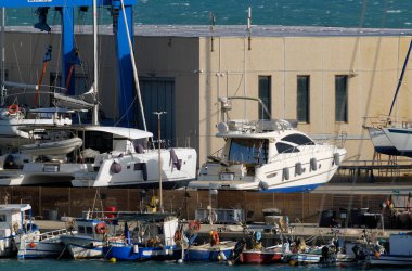 İtalya, Sicilya, Marina di Ragusa (Ragusa Eyaleti), 28 Nisan 2024, limanda yerel balıkçı tekneleri ve lüks yatlar - EDITORIAL