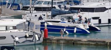 İtalya, Sicilya, Akdeniz, Marina di Ragusa (Ragusa ili); 12 Mayıs 2024, limandaki bir yelkenli teknesinde insanlar - EDITORIAL