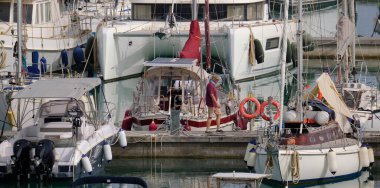 İtalya, Sicilya, Akdeniz, Marina di Ragusa (Ragusa Eyaleti); 16 Mayıs 2024, limandaki insanlar ve lüks yatlar - EDITORIAL