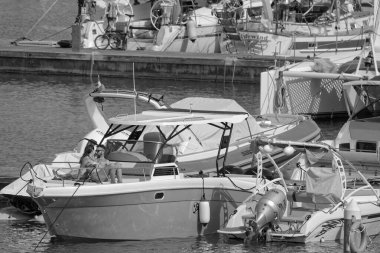 İtalya, Sicilya, Akdeniz, Marina di Ragusa (Ragusa Eyaleti); 19 Mayıs 2024, limanda lüks bir yatta çift - EDITORIAL