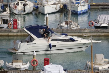 İtalya, Sicilya, Akdeniz, Marina di Ragusa (Ragusa Eyaleti); 19 Mayıs 2024, limanda lüks bir yatta insanlar - EDITORIAL