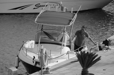 İtalya, Sicilya, Akdeniz, Marina di Ragusa (Ragusa Eyaleti); 19 Mayıs 2024, limandaki bir motorlu teknede balıkçı - EDITORIAL