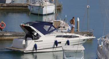 İtalya, Sicilya, Akdeniz, Marina di Ragusa (Ragusa Eyaleti); 23 Mayıs 2024, limanda lüks bir yatta erkekler - EDITORIAL