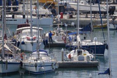 İtalya, Sicilya, Akdeniz, Marina di Ragusa (Ragusa Eyaleti); 25 Mayıs 2024, limandaki insanlar ve lüks yatlar - EDITORIAL