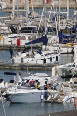 İtalya, Sicilya, Akdeniz, Marina di Ragusa (Ragusa Eyaleti); 25 Mayıs 2024, limanda lüks bir yatta çift - EDITORIAL