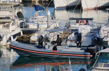 İtalya, Sicilya, Akdeniz, Marina di Ragusa (Ragusa Eyaleti); 26 Mayıs 2024, limandaki lastik bir teknede balıkçı - EDITORIAL