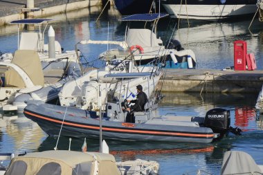 İtalya, Sicilya, Akdeniz, Marina di Ragusa (Ragusa Eyaleti); 26 Mayıs 2024, limandaki lastik bir teknede balıkçı - EDITORIAL