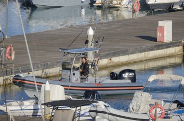 İtalya, Sicilya, Akdeniz, Marina di Ragusa (Ragusa Eyaleti); 26 Mayıs 2024, limandaki lastik bir teknede balıkçı - EDITORIAL