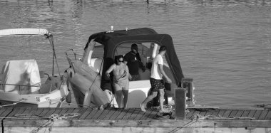 İtalya, Sicilya, Akdeniz, Marina di Ragusa (Ragusa Eyaleti); 26 Mayıs 2024, limanda lüks bir yatta çift - EDITORIAL