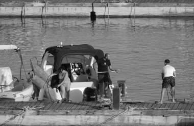 İtalya, Sicilya, Akdeniz, Marina di Ragusa (Ragusa Eyaleti); 26 Mayıs 2024, limanda lüks bir yatta çift - EDITORIAL