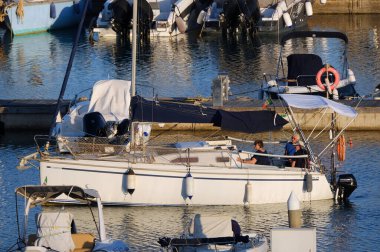 İtalya, Sicilya, Akdeniz, Marina di Ragusa (Ragusa ili); 31 Mayıs 2024, limandaki bir yelkenli teknesinde insanlar - EDITORIAL