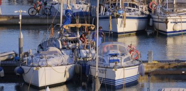 İtalya, Sicilya, Akdeniz, Marina di Ragusa (Ragusa ili); 31 Mayıs 2024, limandaki bir yelkenli teknesinde çift - EDITORIAL