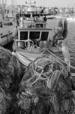 İtalya, Sicilya, Marina di Ragusa (Ragusa Eyaleti), balıkçı ağları, yerel ahşap balıkçı tekneleri ve limanda lüks yatlar