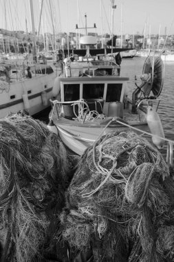 İtalya, Sicilya, Marina di Ragusa (Ragusa Eyaleti), balıkçı ağları, yerel ahşap balıkçı tekneleri ve limanda lüks yatlar