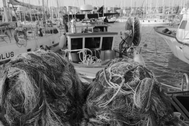 İtalya, Sicilya, Marina di Ragusa (Ragusa Eyaleti), balıkçı ağları, yerel ahşap balıkçı tekneleri ve limanda lüks yatlar