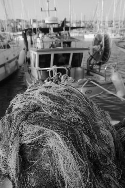 İtalya, Sicilya, Marina di Ragusa (Ragusa Eyaleti), balıkçı ağları, yerel ahşap balıkçı tekneleri ve limanda lüks yatlar