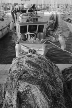 İtalya, Sicilya, Marina di Ragusa (Ragusa Eyaleti), balıkçı ağları, yerel ahşap balıkçı tekneleri ve limanda lüks yatlar