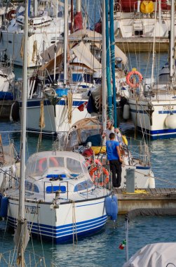 İtalya, Sicilya, Akdeniz, Marina di Ragusa (Ragusa ili); 3 Haziran 2024, limandaki bir yelkenli teknesinde insanlar - EDITORIAL
