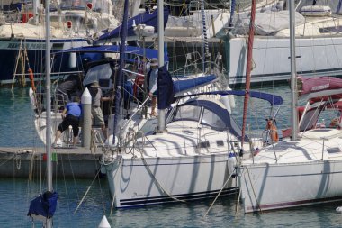 İtalya, Sicilya, Akdeniz, Marina di Ragusa (Ragusa Eyaleti); 6 Haziran 2024, limandaki bir yelkenli ve lüks yatlarda erkekler - EDITORIAL