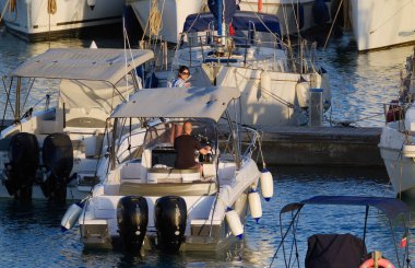 İtalya, Sicilya, Akdeniz, Marina di Ragusa (Ragusa Eyaleti); 8 Haziran 2024, limanda lüks bir yatta çift - EDITORIAL