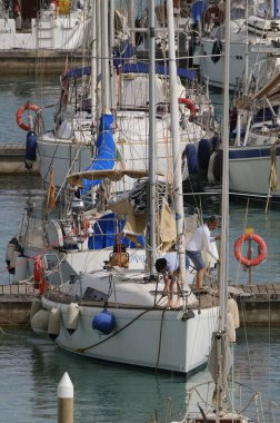 İtalya, Sicilya, Akdeniz, Marina di Ragusa (Ragusa ili); 9 Haziran 2024, limandaki bir yelkenli teknesinde çift - EDITORIAL