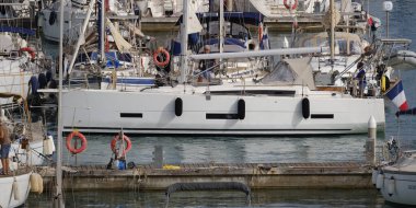 İtalya, Sicilya, Akdeniz, Marina di Ragusa (Ragusa ili); 9 Haziran 2024, limandaki bir yelkenli teknesinde çift - EDITORIAL