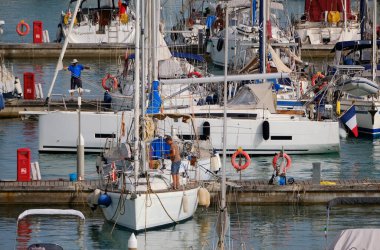 İtalya, Sicilya, Akdeniz, Marina di Ragusa (Ragusa ili); 9 Haziran 2024, limandaki bir yelkenli teknesinde çift - EDITORIAL