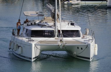 İtalya, Sicilya, Akdeniz, Marina di Ragusa (Ragusa ili); 10 Haziran 2024, limanda bir katamaran yelkenli teknesinde çift - EDITORIAL