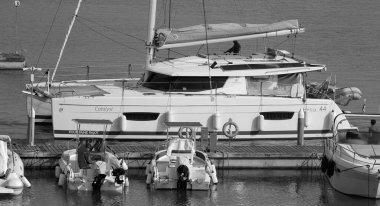 İtalya, Sicilya, Akdeniz, Marina di Ragusa (Ragusa ili); 10 Haziran 2024, limanda bir katamaran yelkenli teknesinde çift - EDITORIAL