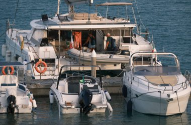 İtalya, Sicilya, Akdeniz, Marina di Ragusa (Ragusa ili); 11 Haziran 2024, limanda bir katamaran yelkenli teknesinde çift - EDITORIAL