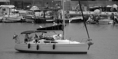 İtalya, Sicilya, Akdeniz, Marina di Ragusa (Ragusa ili); 13 Haziran 2024, limandaki bir yelkenli teknesinde insanlar - EDITORIAL