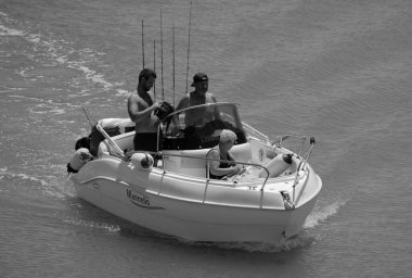 İtalya, Sicilya, Akdeniz, Marina di Ragusa (Ragusa Eyaleti); 15 Haziran 2024, limandaki bir motorlu teknede balıkçı - EDITORIAL