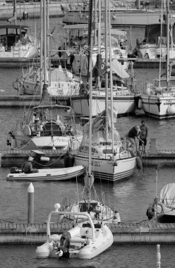 İtalya, Sicilya, Akdeniz, Marina di Ragusa (Ragusa Eyaleti); 16 Haziran 2024, limandaki bir yelkenli teknesinde adam - EDITORIAL