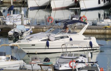 İtalya, Sicilya, Akdeniz, Marina di Ragusa (Ragusa ili); 22 Haziran 2024, limanda lüks bir yatta çift - EDITORIAL