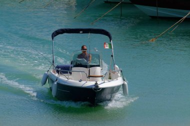 İtalya, Sicilya, Akdeniz, Marina di Ragusa (Ragusa ili); 23 Haziran 2024, limandaki bir motorlu teknede balıkçı - EDITORIAL