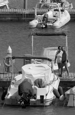 İtalya, Sicilya, Akdeniz, Marina di Ragusa (Ragusa ili); 23 Haziran 2024, limanda insanlar ve motorlu tekneler - EDITORIAL