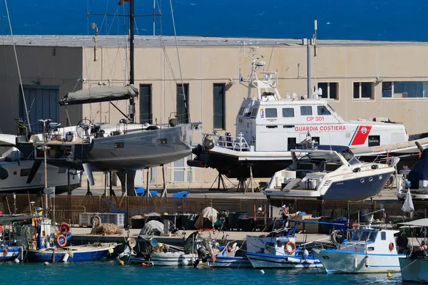 İtalya, Sicilya, Marina di Ragusa (Ragusa Eyaleti), 23 Haziran 2024, limanda yerel balıkçı tekneleri ve lüks yatlar - EDITORIAL