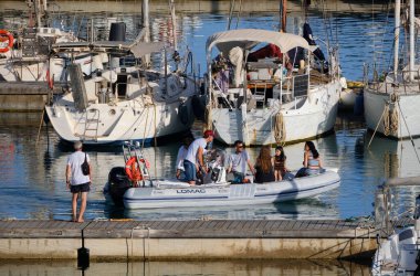 İtalya, Sicilya, Akdeniz, Marina di Ragusa (Ragusa Eyaleti); 28 Haziran 2024, limandaki kauçuk bir teknede insanlar - EDITORIAL