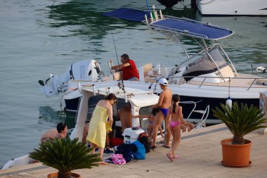 İtalya, Sicilya, Akdeniz, Marina di Ragusa (Ragusa ili); 30 Haziran 2024, limandaki insanlar, motorlu tekneler ve lüks yatlar - EDITORIAL