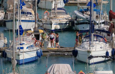 İtalya, Sicilya, Akdeniz, Marina di Ragusa (Ragusa Eyaleti); 4 Temmuz 2024, limandaki insanlar ve lüks yatlar - EDITORIAL